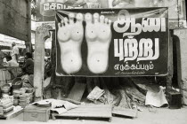 Street reflexologists open air clinic. Poster of bottom of feet.  Black and white image.