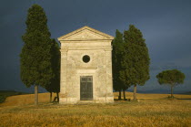 Small stone chapel and cyrpress trees near San Quirico d Orcia.