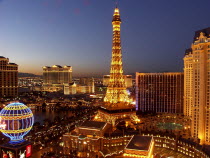 Paris Hotel exterior with the mock Eiffel Tower and Hot air ballon in the foreground lit up at night