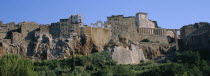 Built on cliffs above Lente Valley with caves made during etruscan era.