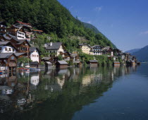 Village of Hallstatt on West of Hallstattersee. Wooden fronted buildings with balconies  hotels  boat sheds  next to lake.