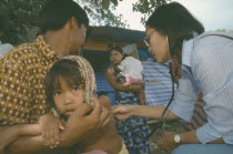 A Burmese medic attends to a sick child caught in the Tsunami