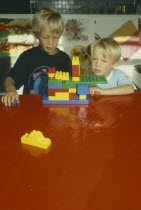 Children playing with brightly coloured building bricks. Colored