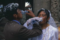 Wedding in El Monticulo. Bride and Groom interlocking arms and drinking.