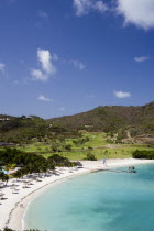 Jambu Beach in Carenage Bay at Raffles Resort with the Trump International Golf Course behind