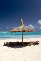 Palapa thatched shelter and sunbeds on Godahl Beach at Raffles Resort with speedboat passing along the bayBeaches Caribbean Sand Sandy Seaside Shore Tourism West Indies Windward Islands Scenic Beach...