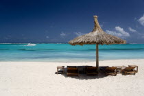 Palapa thatched shelter and sunbeds on Godahl Beach at Raffles Resort with speedboat passing along the bayBeaches Caribbean Sand Sandy Seaside Shore Tourism West Indies Windward Islands  Beaches Car...