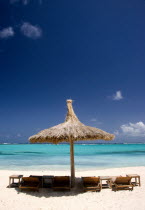 Palapa thatched shelter and sunbeds on Godahl Beach at Raffles Resort