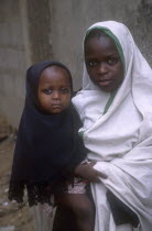 Young girl holding baby.