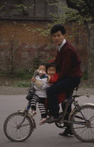 Man and two small children on a bicycleCenter Centre