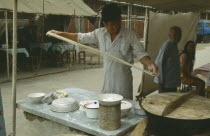 Man making noodles at street stall.