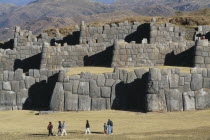 People walking infront of the Inca walls.