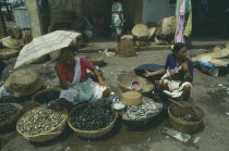 The fish market with smiling woman holding umbrella as a sun shade