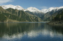 View over the lake toward snow capped mountain peaks