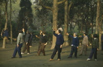 Group exercise in park at dawn.