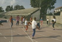 Children performing warm up exercises on School track