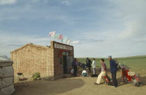 Mongolians gathering for sheep work with motorbikes and bicycles parked