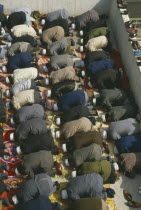 View looking down on rows of muslims at prayer.