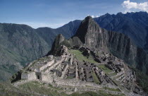 View looking down on hilltop Inca city ruins surrounded by mountainous landscape