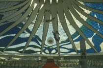 Cathedral interior with patterned glass roof and statues suspended from the ceiling