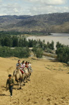 People on traveling up hill on camels