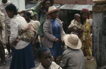 Busy street scene; men  women and children.