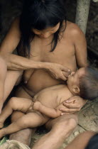 Waorani tribeswoman breastfeeding baby.