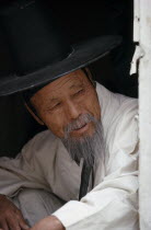 Portrait of elderly Confucian Priest in traditional white robe and kat horsehair hat