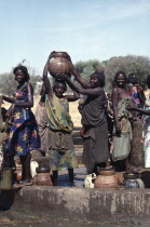 Group of Chadian refugee women collecting water from well.