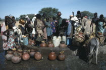 Chadian refugees gathered at well in settlement near El Geneina.