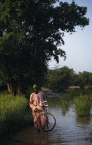 Man with bike wading through water