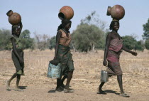 Chadian refugee women collecting water from well in camp near El Geneina.