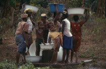 Women and children collecting water at stand pipe.