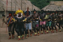 The Indians dance to celebrate reclaiming their land. They have red and black died skin decoration and some carry spears.Brasil Kreen Akore