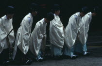 Nikko.  Shinto priests watch and bow as the omikoshi or residence of the local kami or deity is carried past at Futara-gu Jinga during the Tosho-gu festival.Mikoshi