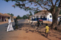 Street scene with people and roadside vendor in town in the Casheu region.