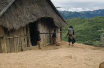 Meo children outside thatched house in village near Luang Prabang.