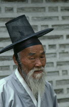 Portrait of elderly man in traditional robe and kat horsehair hat of Confucian believer.