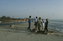 People buying freshly caught fish on the beach