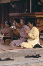 Buddhist people sitting in prayer