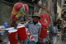 Man carrying plastic goods for sale on the street