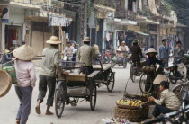 Busy street with bicycles cyclos and street vendors