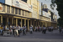 Mopeds in a street lined with colonnaded buildings