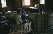 Musicians playing classical musical instruments comprising of drums and percussion instruments in an elaborately carved circle.Burma Myanmar