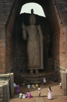 Large standing Buddha towering over people below