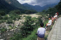 Ssang-Chon River.  Children sitting beside almost dry river bed