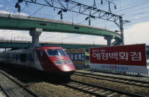 High speed train passing through station in city suburbs