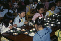 Nursery school pupils eating lunch.