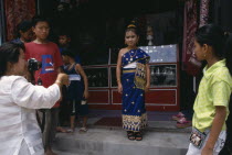 Little girl in traditional dress waiting to have her photograph taken at New Year.