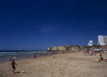 View along beach with children playing beach soccer